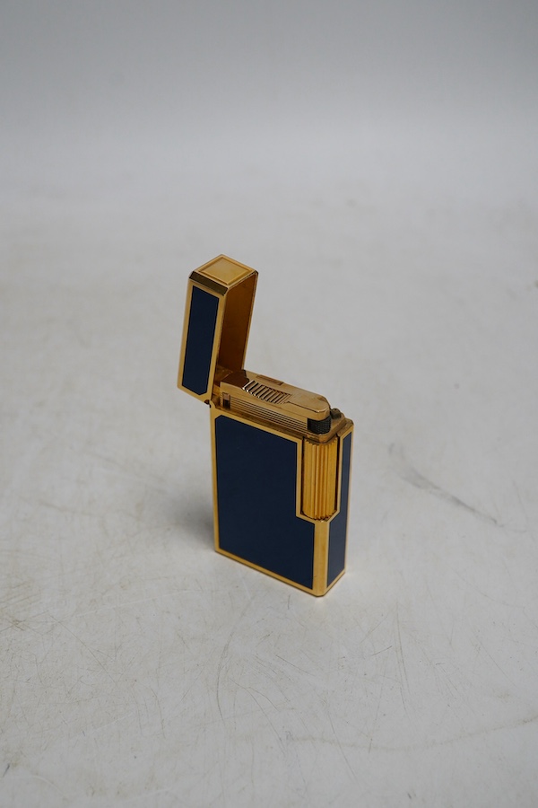 A Dupont gilt metal and blue enamel cigarette lighter with Japanese characters to the side, boxed with papers and a Piaget Montres Watches folding knife, cased. Condition - good